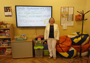 Nauczyciel organizator turnieju warcabowego pod tablicą