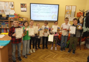 Uczestnicy turnieju warcabowego z dyplomami i nagrodami