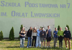 Uczniowie stoją na trawie