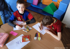 Uczniowie pracują przy stoliku