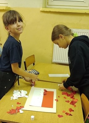 Dziewczynki przyklejają motylki biało-czerwone 