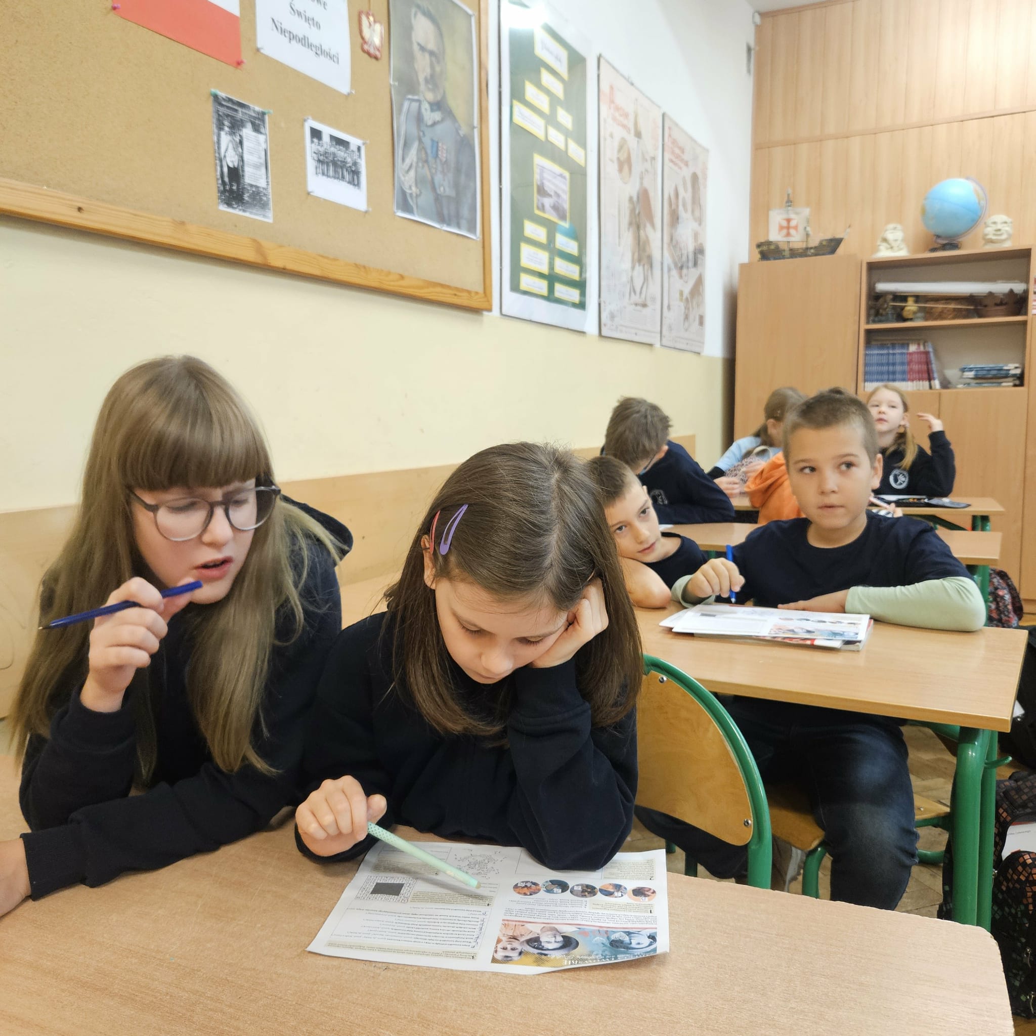 Uczniowie siedzą w sali historycznej