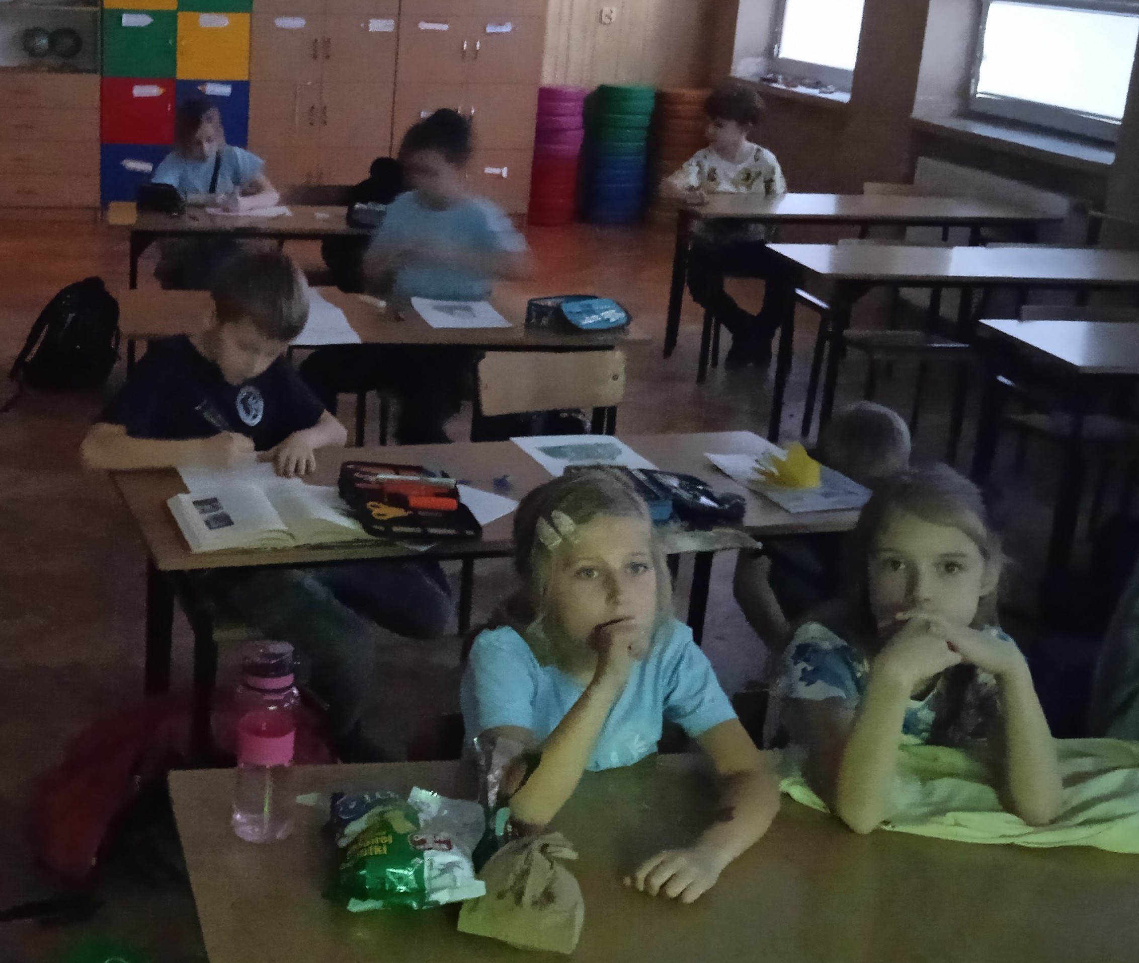 Dzieci siedzą w ławkach