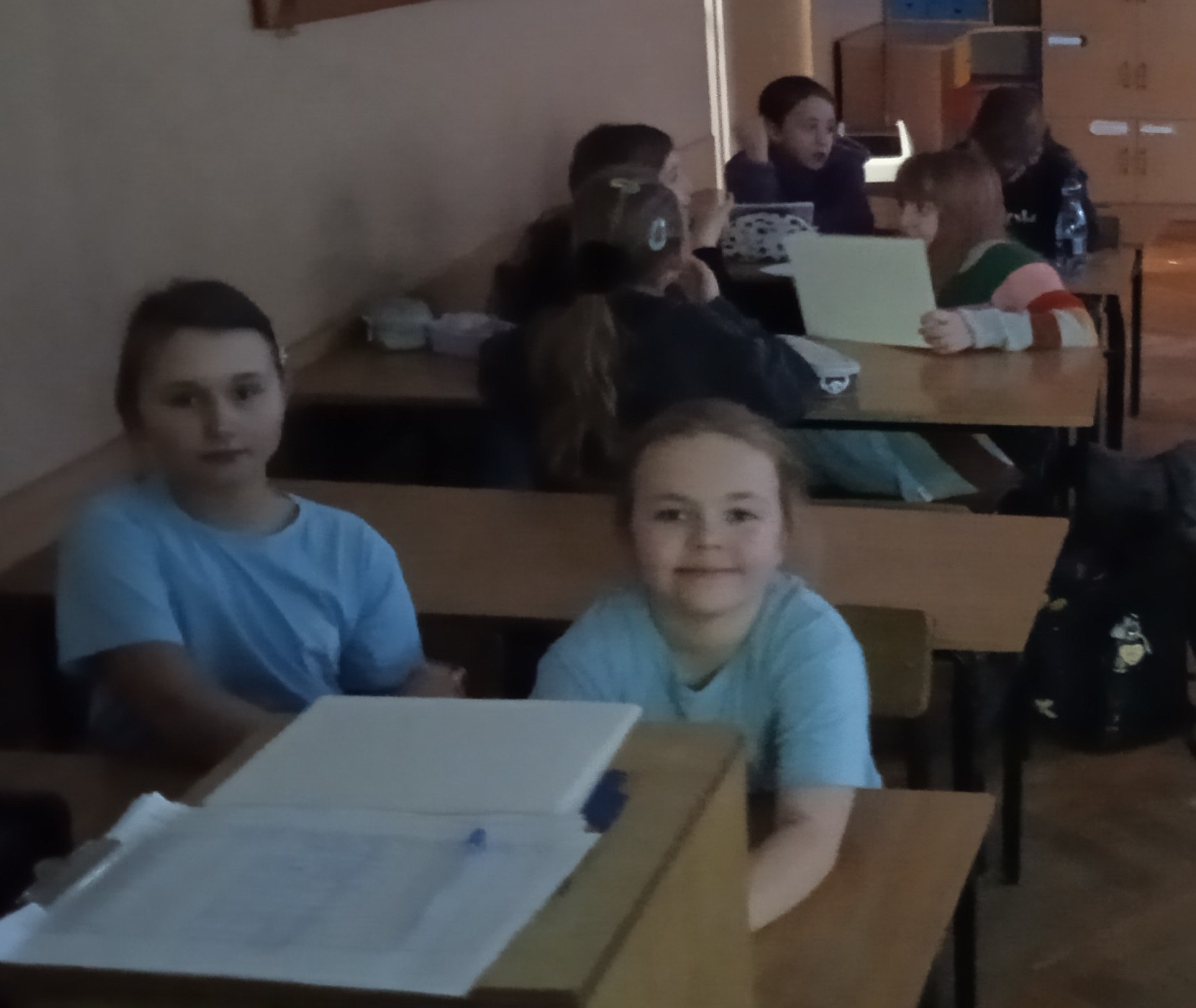 Uczniowie siedzą w ławkach