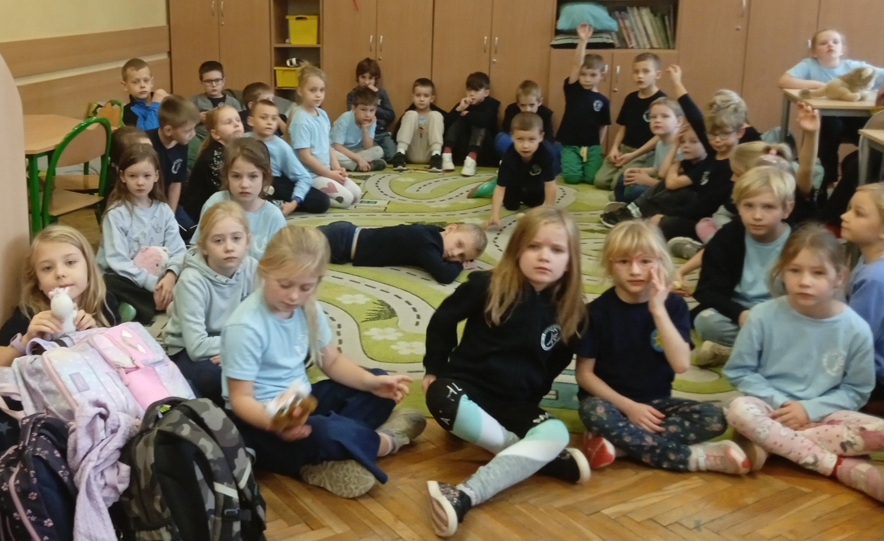 Dzieci siedzą na dywanie