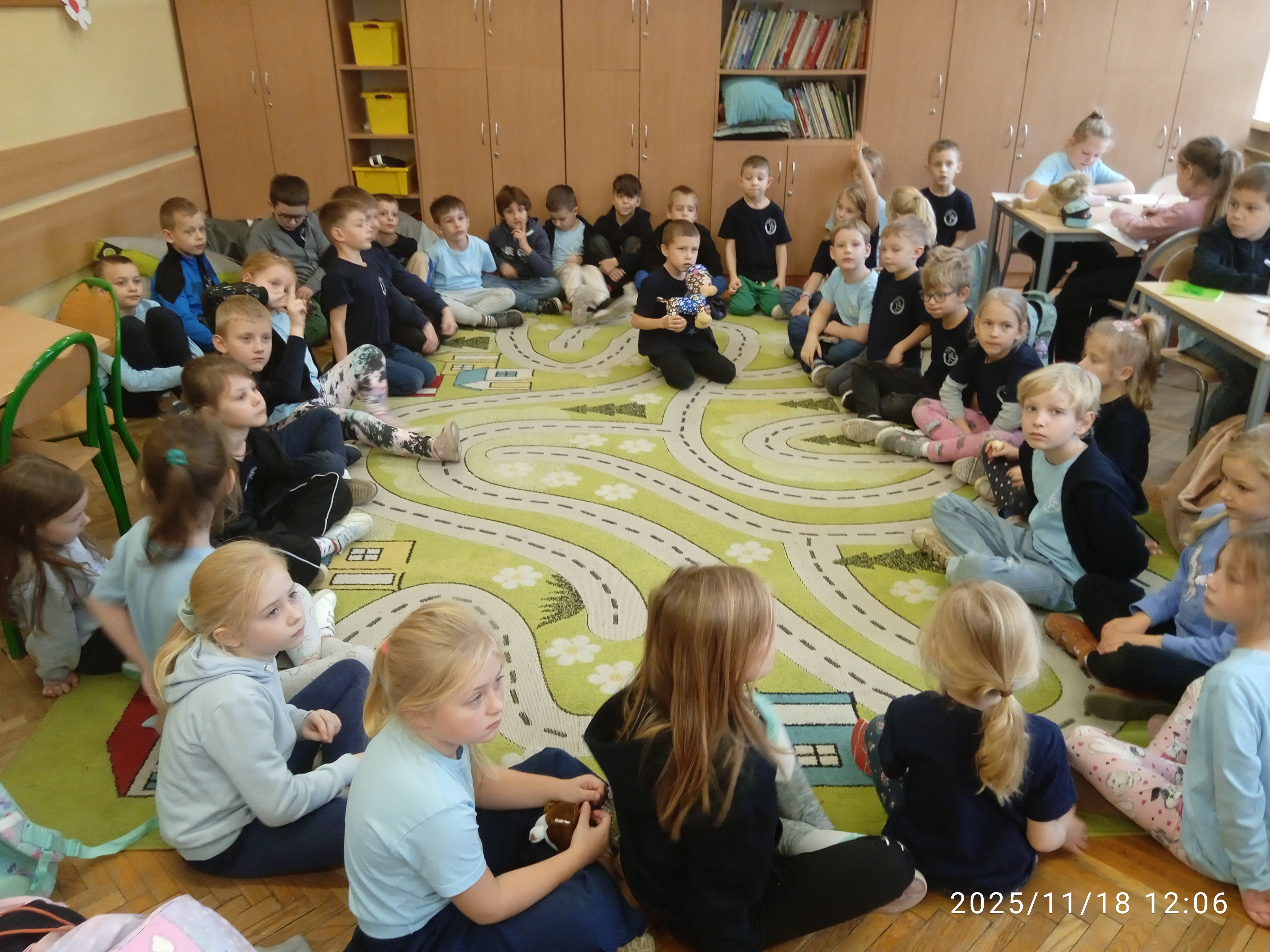 Dzieci siedzą na dywanie