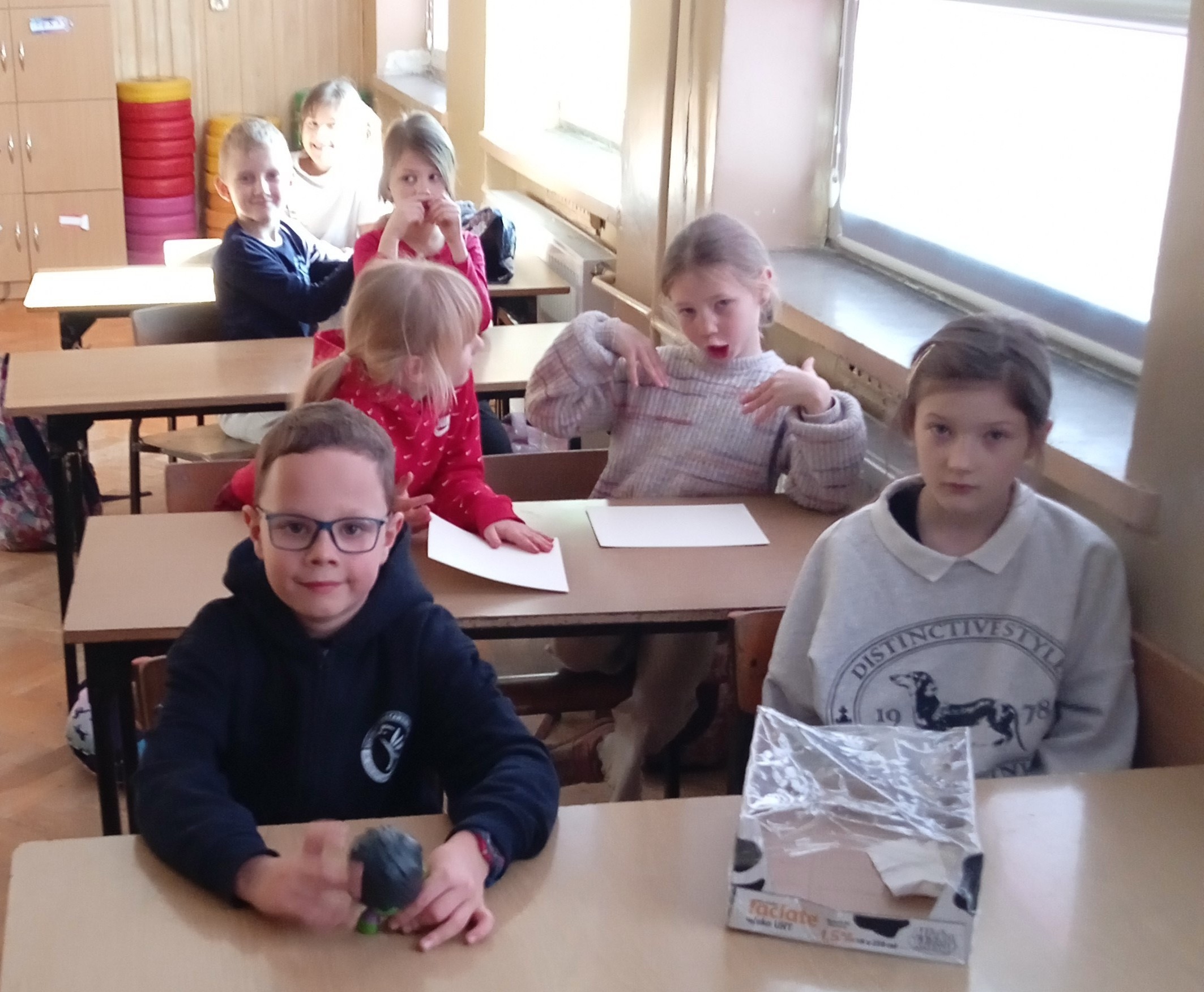 Uczniowie siedzą w ławkach