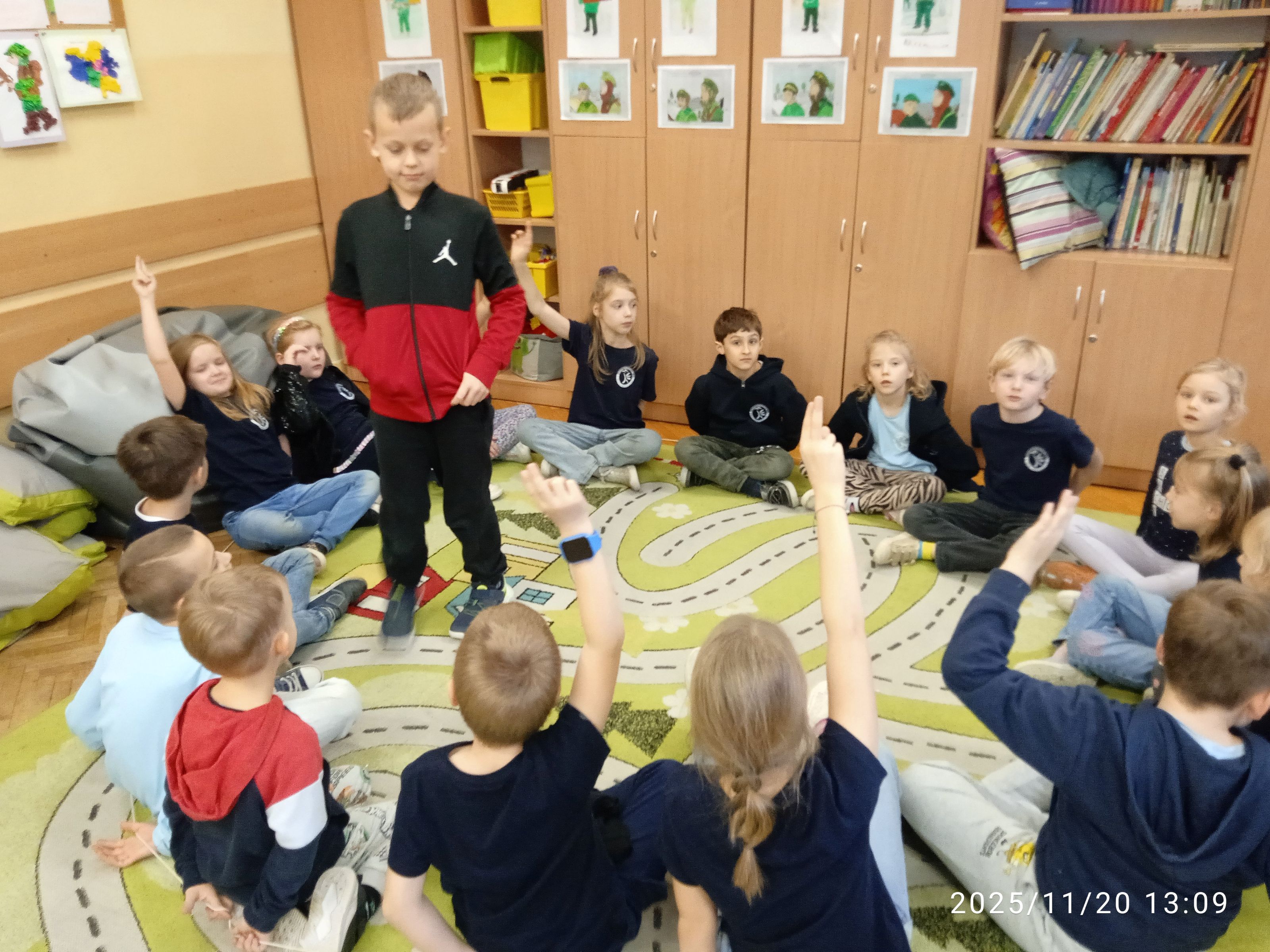 Uczniowie bawią się na dywanie