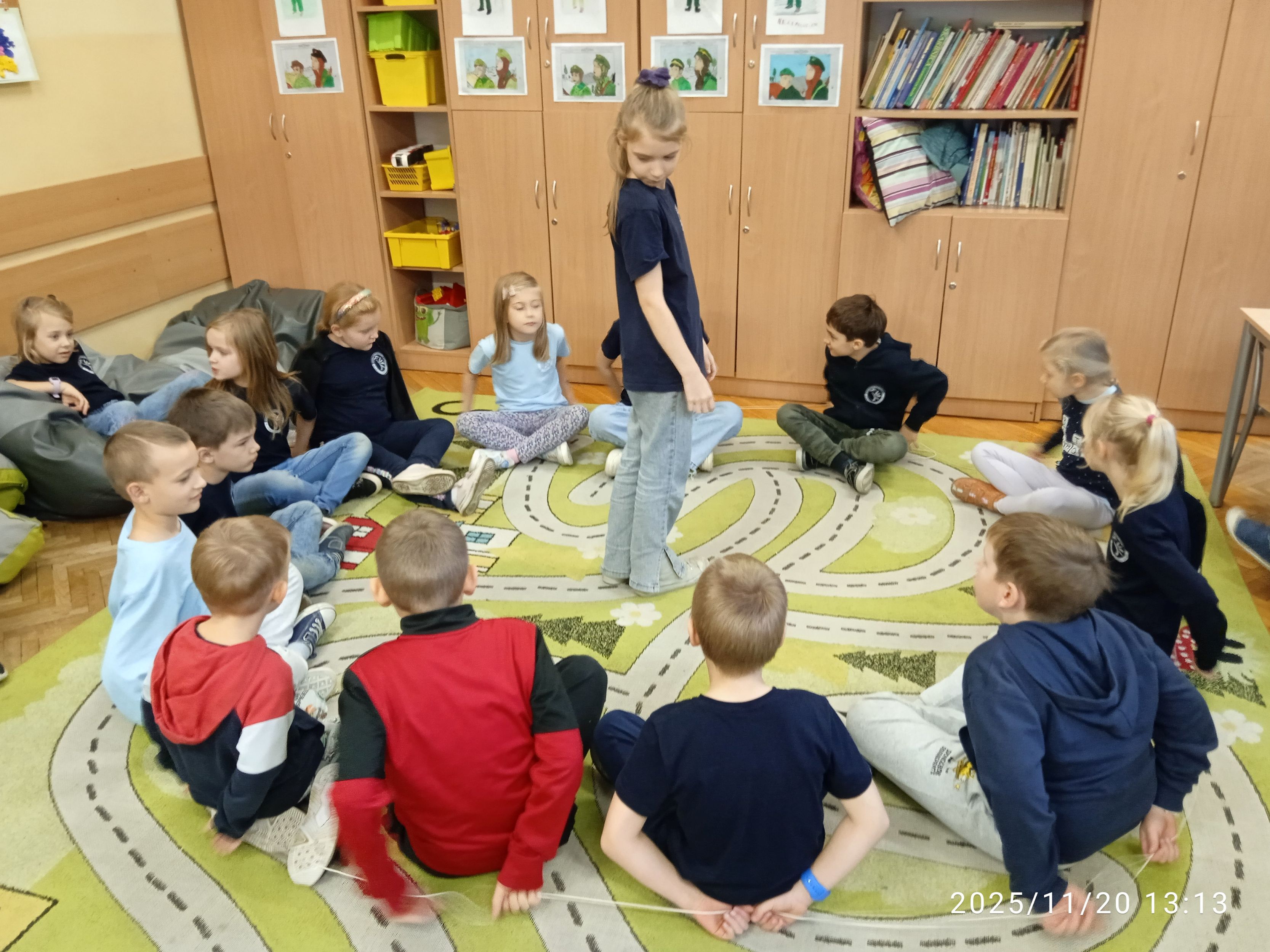 Uczniowie bawią się na dywanie