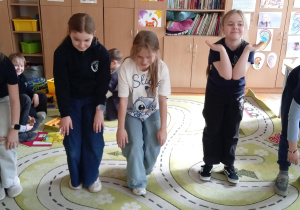 Uczniowie stoją na dywanie