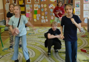 Uczniowie tańczą na dywanie