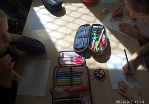 Uczniowie pracują przy stoliku