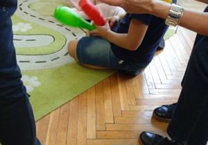 Uczniowie siedzą na dywanie