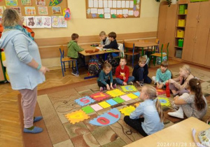 Nauczycielka wyjaśnia zasady zabawy andrzejkowej w kole