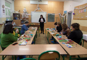 Nauczyciel wyjaśnia wykonanie pracy plastycznej