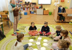 Dzieci siedzą w kole na dywanie wykonują ćwiczenie na myślenie