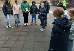 Uczniowie stoją przed pomnikiem