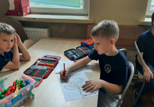 Uczeń koloruje pracę plastyczna o roślinach