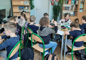 Uczniowie tworzą dobre uczynki na kartkach