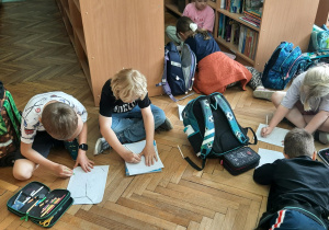 Dzieci rysują kredkami i mazakami wymarzony plac zabaw