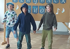 Uczniowie stoją w bluzach z kapturem