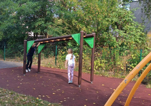 Uczennice korzystają z drabinek na placu zabaw