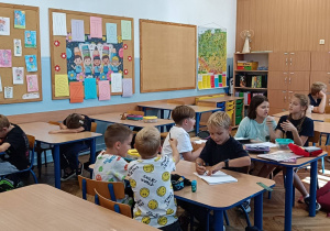 Dzieci pracują podczas zajęć świetlicowych wykonując pracę plastyczną