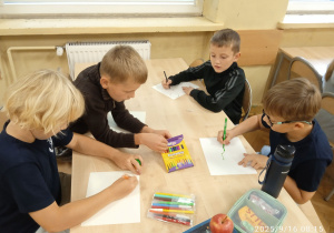 Uczniowie pracują przy stoliku