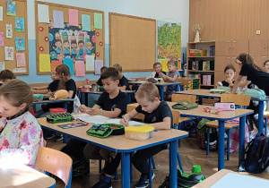 Uczniowie na zajęciach świetlicowych pracują w grupach przy stolikach