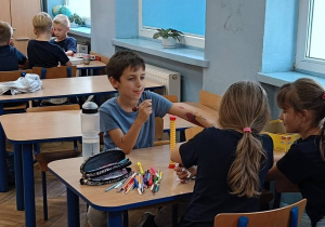 Uczniowie wykonują prace plastyczną dotycząca konkursu