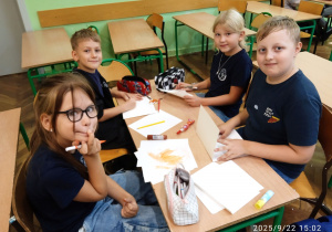 Uczniowie siedzą przy stoliku