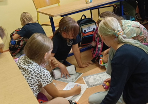 Dziewczynki współpracują ze sobą wykonując ćwiczenie plastyczne o jesieni