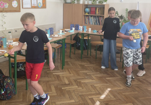 Uczniowie niosą warzywo na łyżeczce