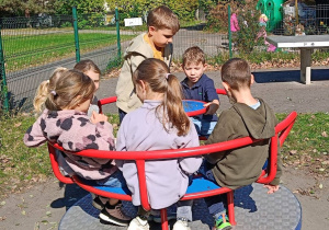Dzieci współpracują ze sobą w czasie zabawy rówieśniczej na placu
