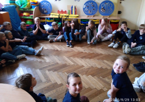 Dzieci siedzą na podłodze