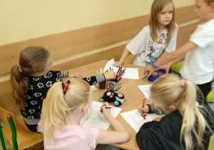 Uczniowie siedzą przy stoliku