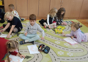 Dzieci kolorują szablon ucha na dźwięki jakie słyszą