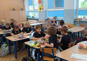 Dzieci wykonują zadanie praktyczne podczas zajęć uspołeczniających
