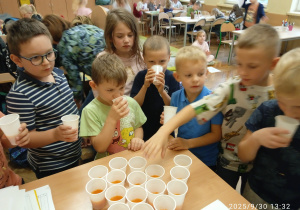 Uczniowie częstują się sokiem