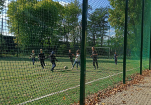 Uczniowie z klasy 2 i 3 podczas zabawy sportowej na boisku