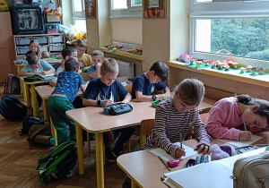 Dzieci wykonują ćwiczenie plastyczne o domowym zwierzątku