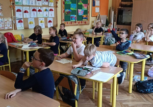 Dzieci uczestniczą w zabawie w kalambury o zwierzętach domowych