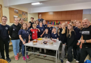 Uczniowie z nauczycielem stoją w klasie