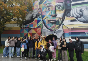 Grupa uczniów stoi przed graffiti