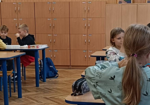 Uczniowie wykonują ćwiczenie praktyczne przy stolikach o zdrowym odżywianiu