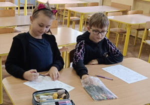 Dzieci pracują w ławce nad kartą pracy o jesiennych warzywach