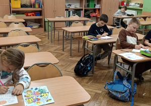 Dzieci wykonują ćwiczenie plastyczne kolorują jesienne warzywa z ogródka