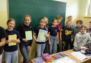 Uczniowie stoją przed tablicą