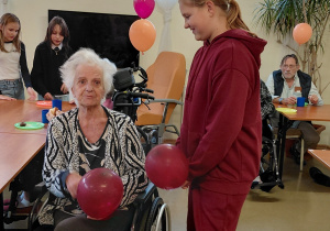 Uczennica wręcza balon
