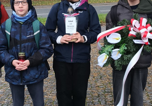 Uczniowie stoją z wiązanką